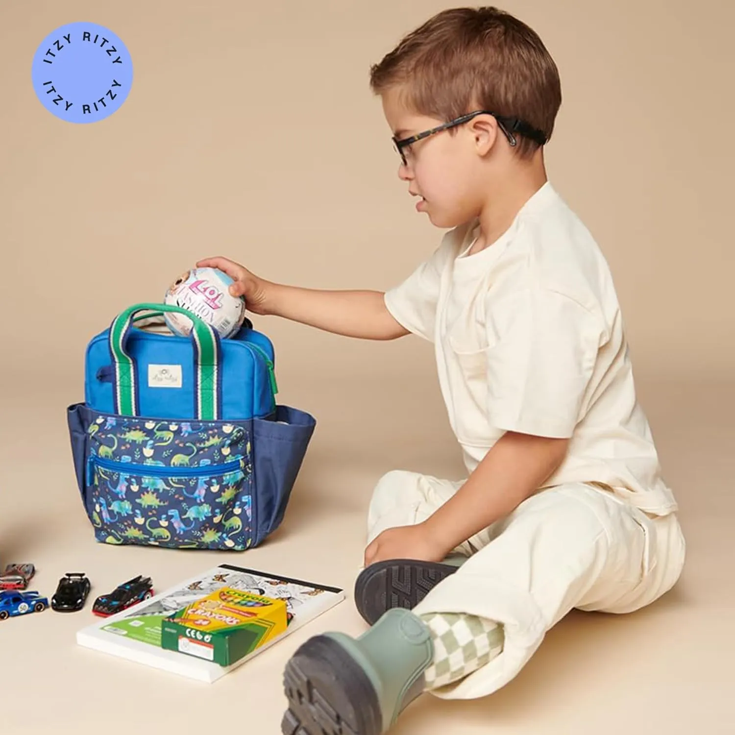 Itzy Ritzy Toddler Backpack - Daycare Bag - Features Adjustable Shoulder Straps, 2 Side Pockets & Spacious Interior with Wipeable Fabric Lining & Name Label, Dinosaur Backpack